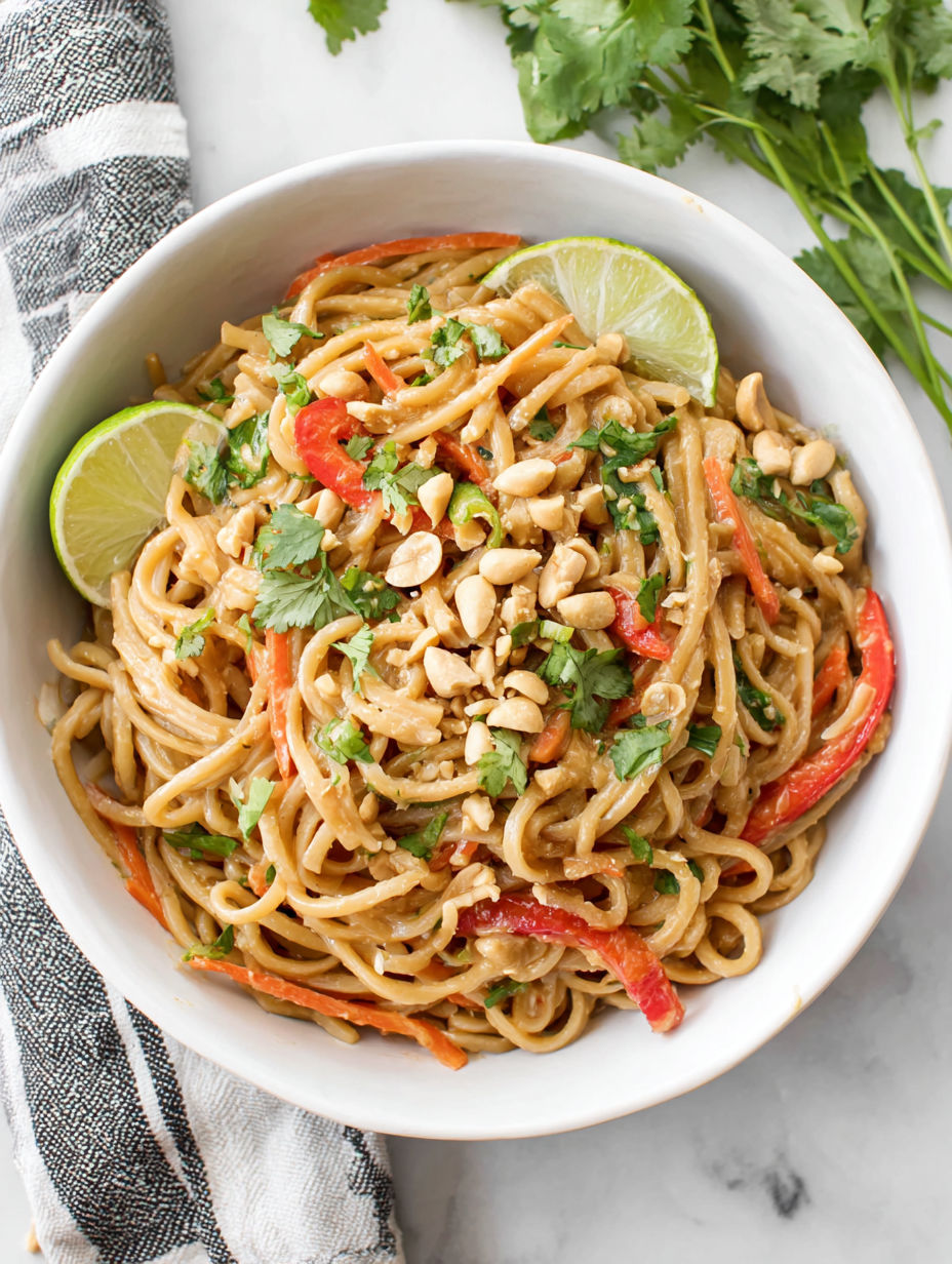 A bowl of noodles with vegetables and nuts.