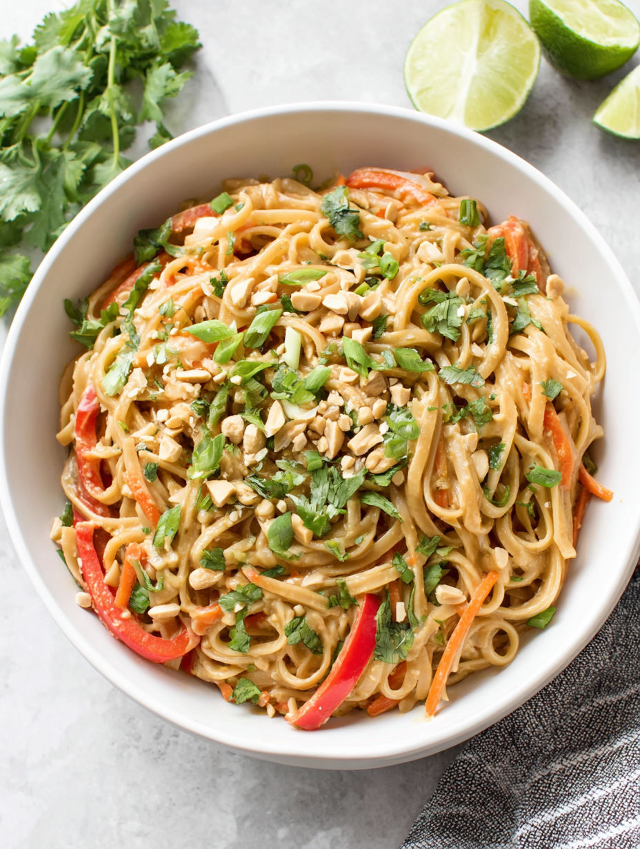 A bowl of noodles with vegetables and nuts.
