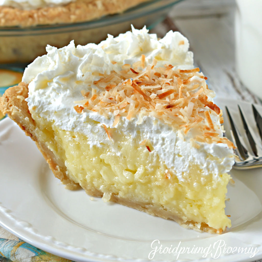 A slice of coconut cream pie with white whipped cream.