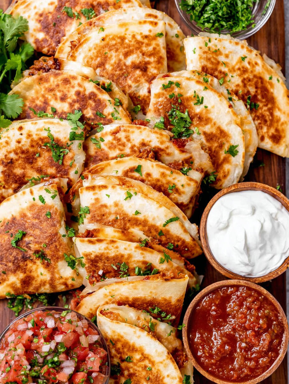 Mini chicken quesadillas with salsa and sour cream.