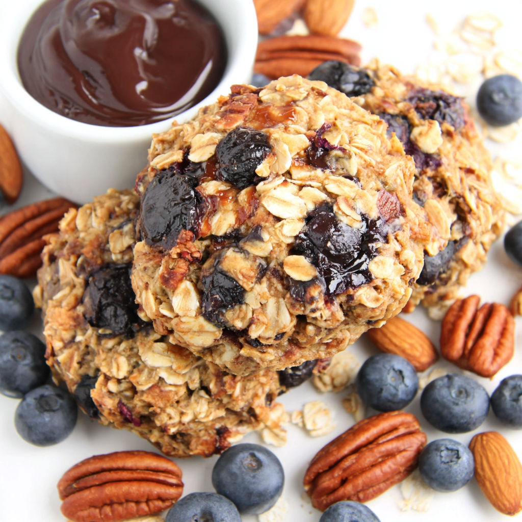 A bowl of oatmeal with chocolate sauce and blueberries.