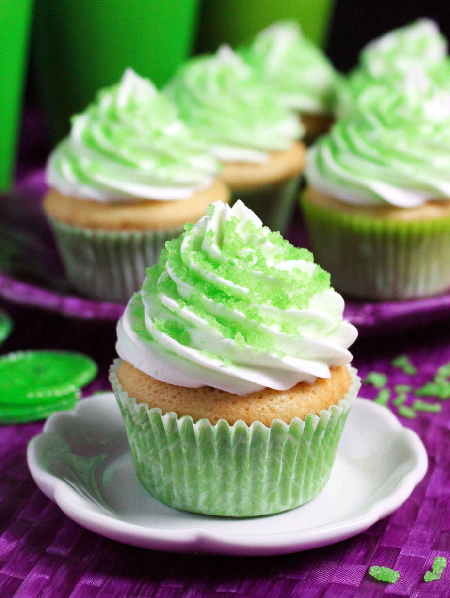 A cupcake with green frosting and white frosting.