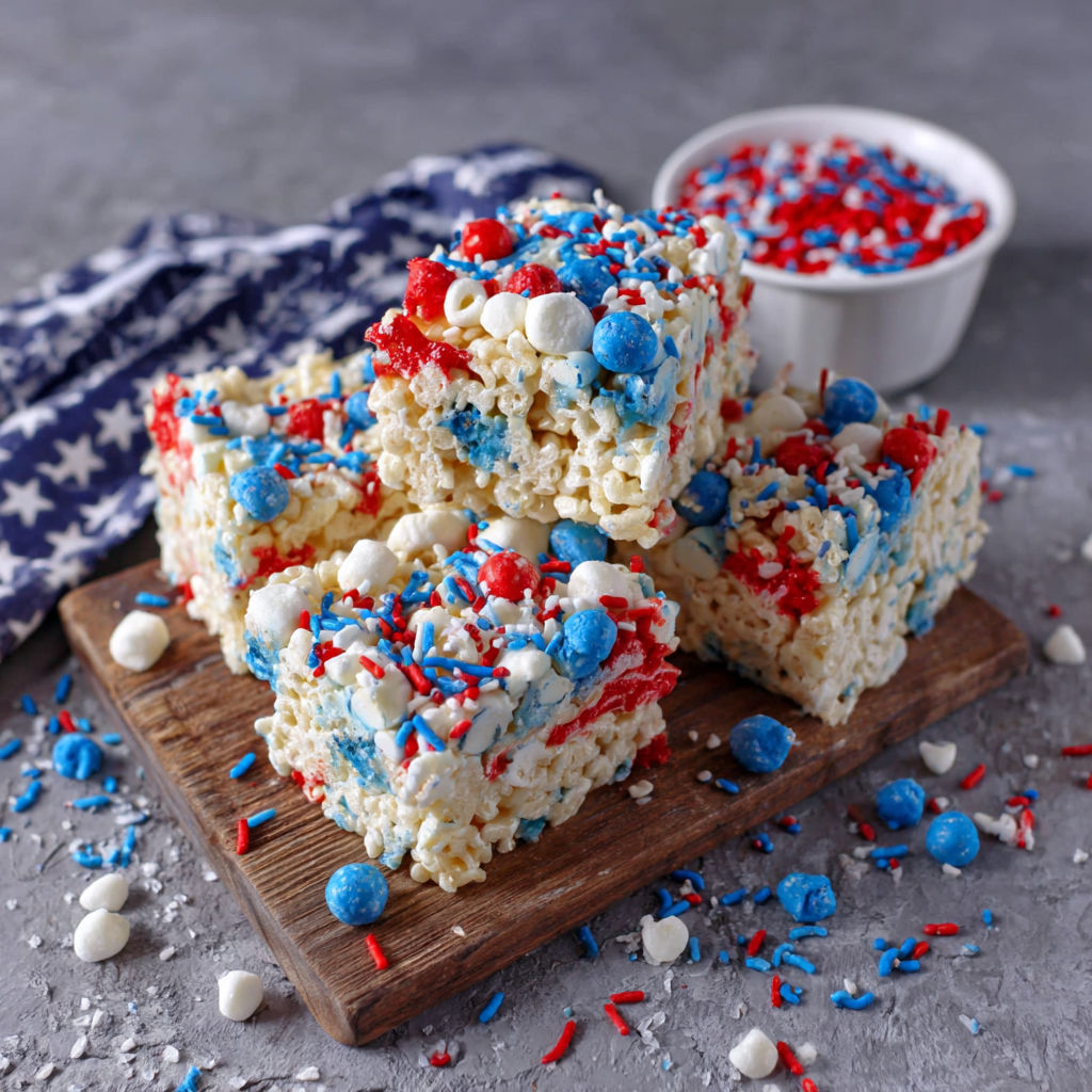 A plate of rice krispie treats with red, white and blue colors.