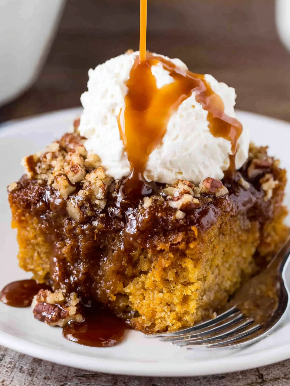 A slice of pumpkin spice cake with whipped cream on top.