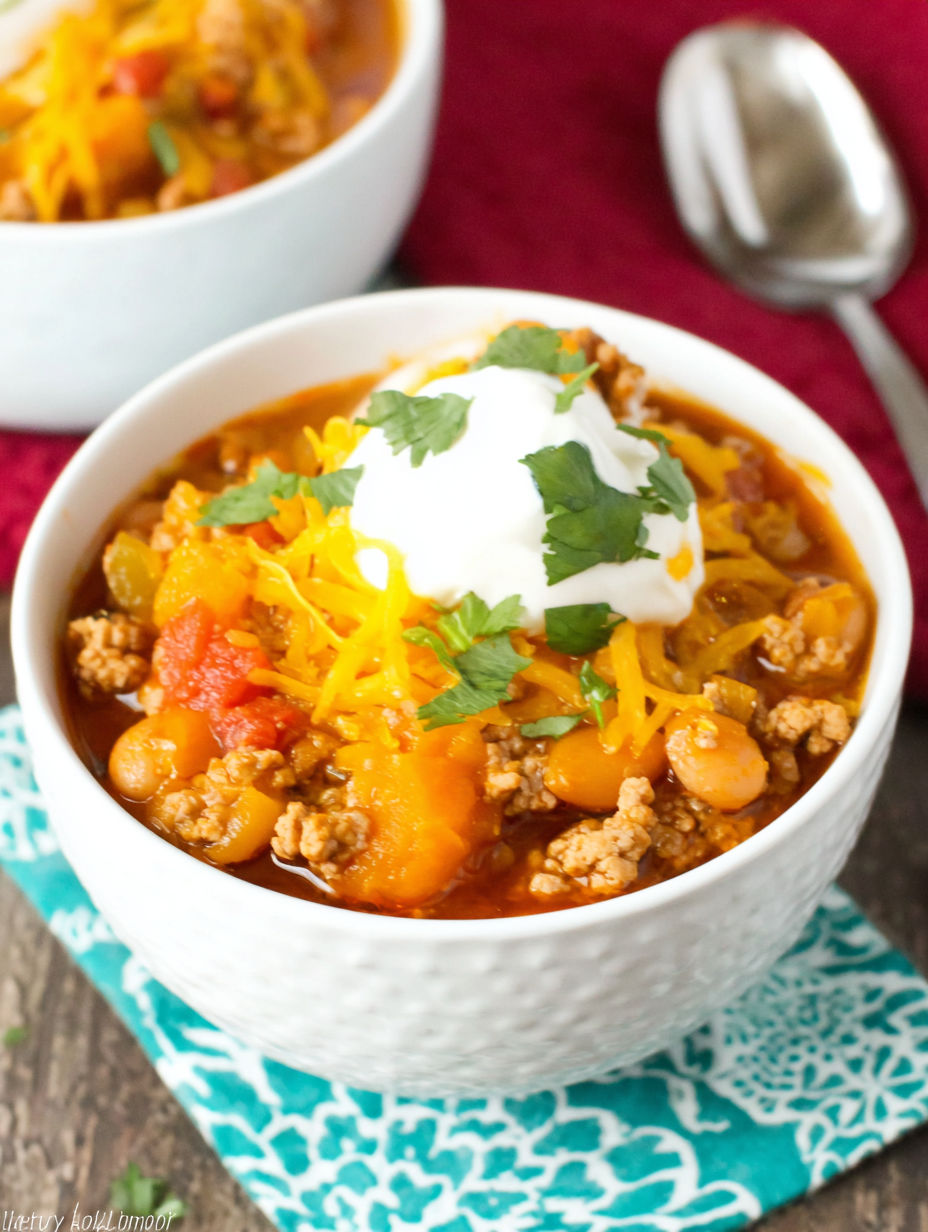 A bowl of chili with a dollop of sour cream on top.