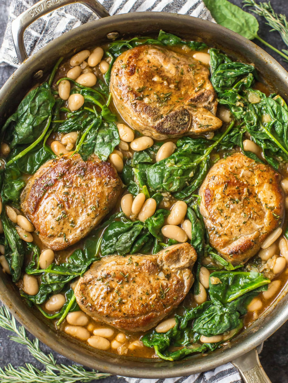 A skillet dinner with pork chops, white beans, and spinach.