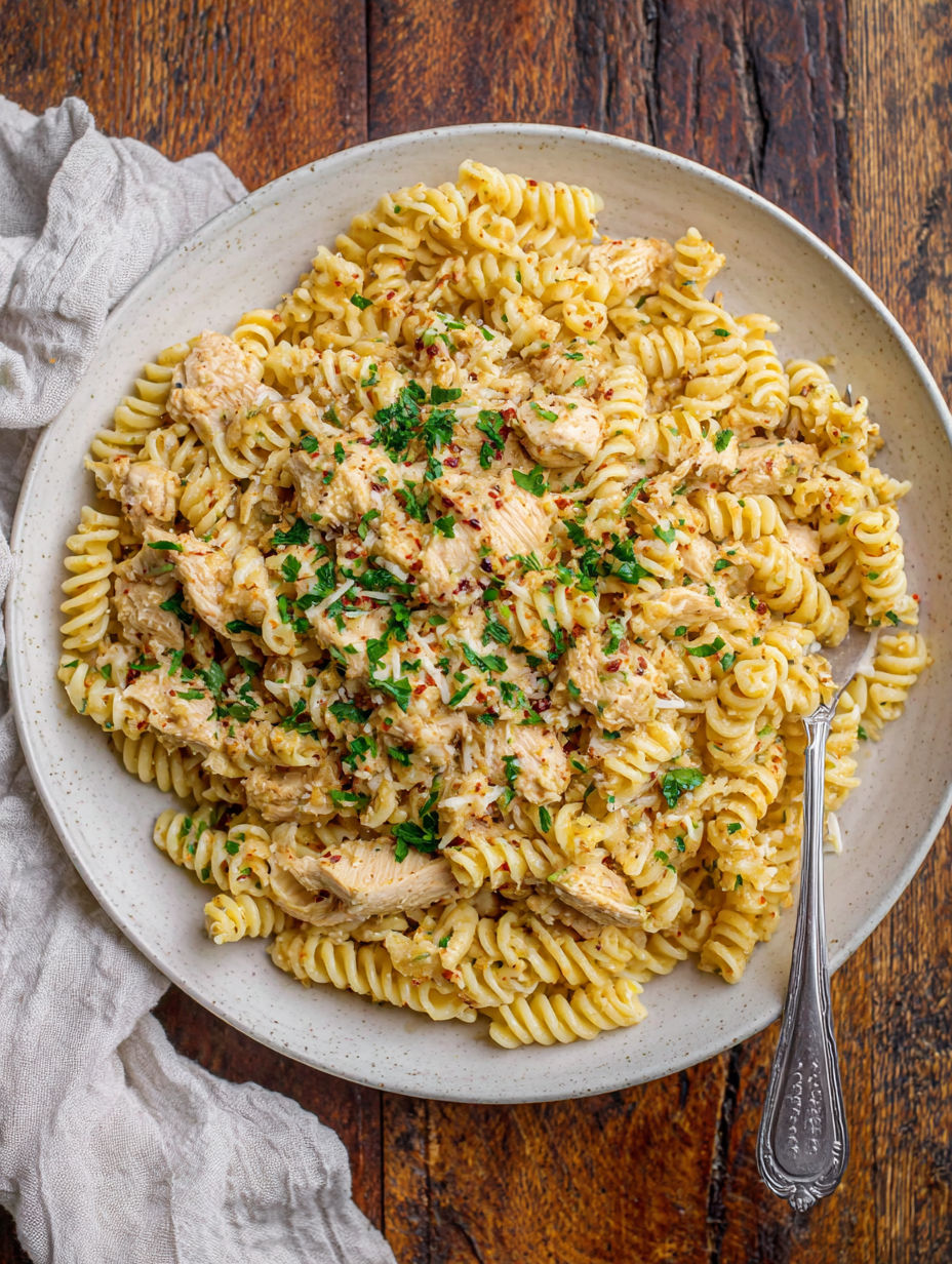 A plate of pasta with chicken and garlic.