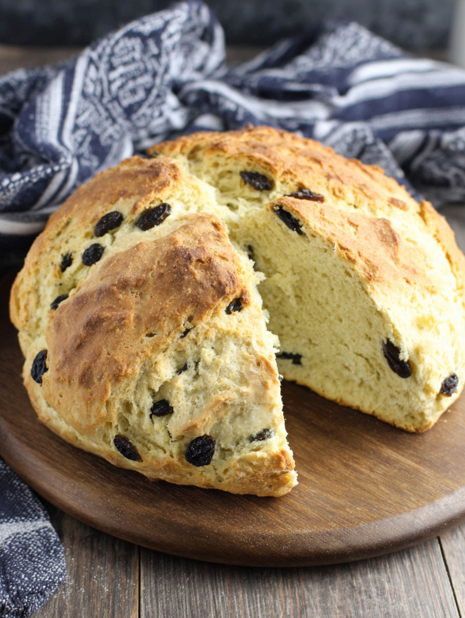 A slice of Irish Soda Bread on a wooden cutting board.