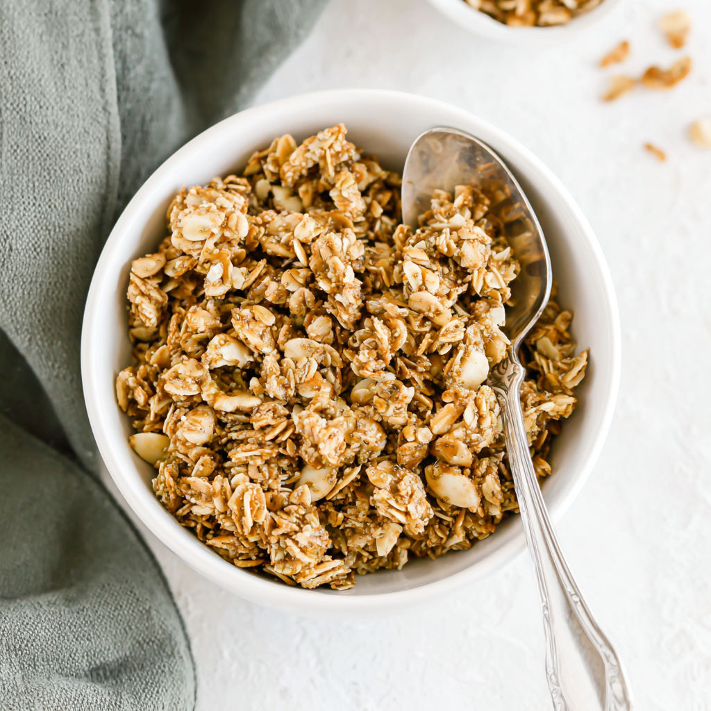 A bowl of granola with a spoon in it.