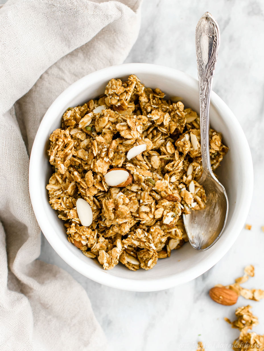 A bowl of granola with a spoon in it.