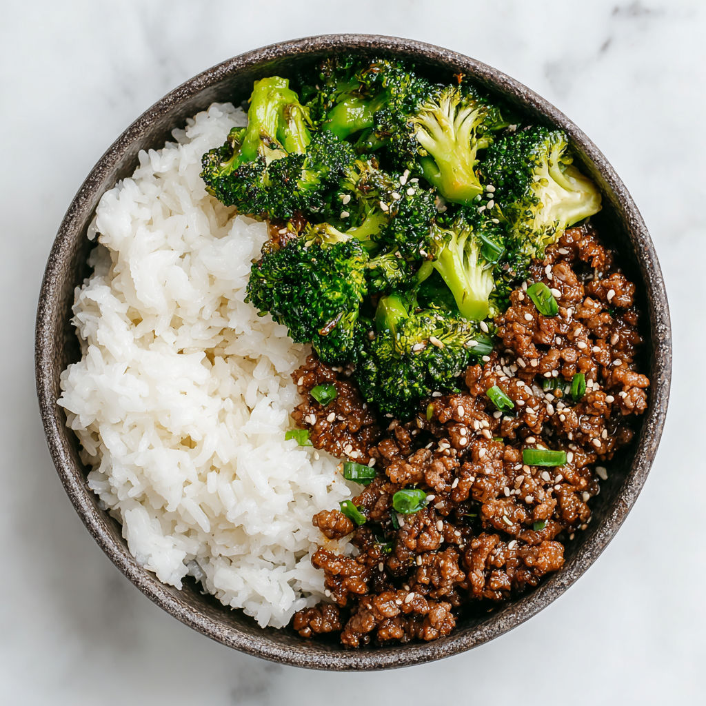 A bowl of ground beef and broccoli stir fry with rice.