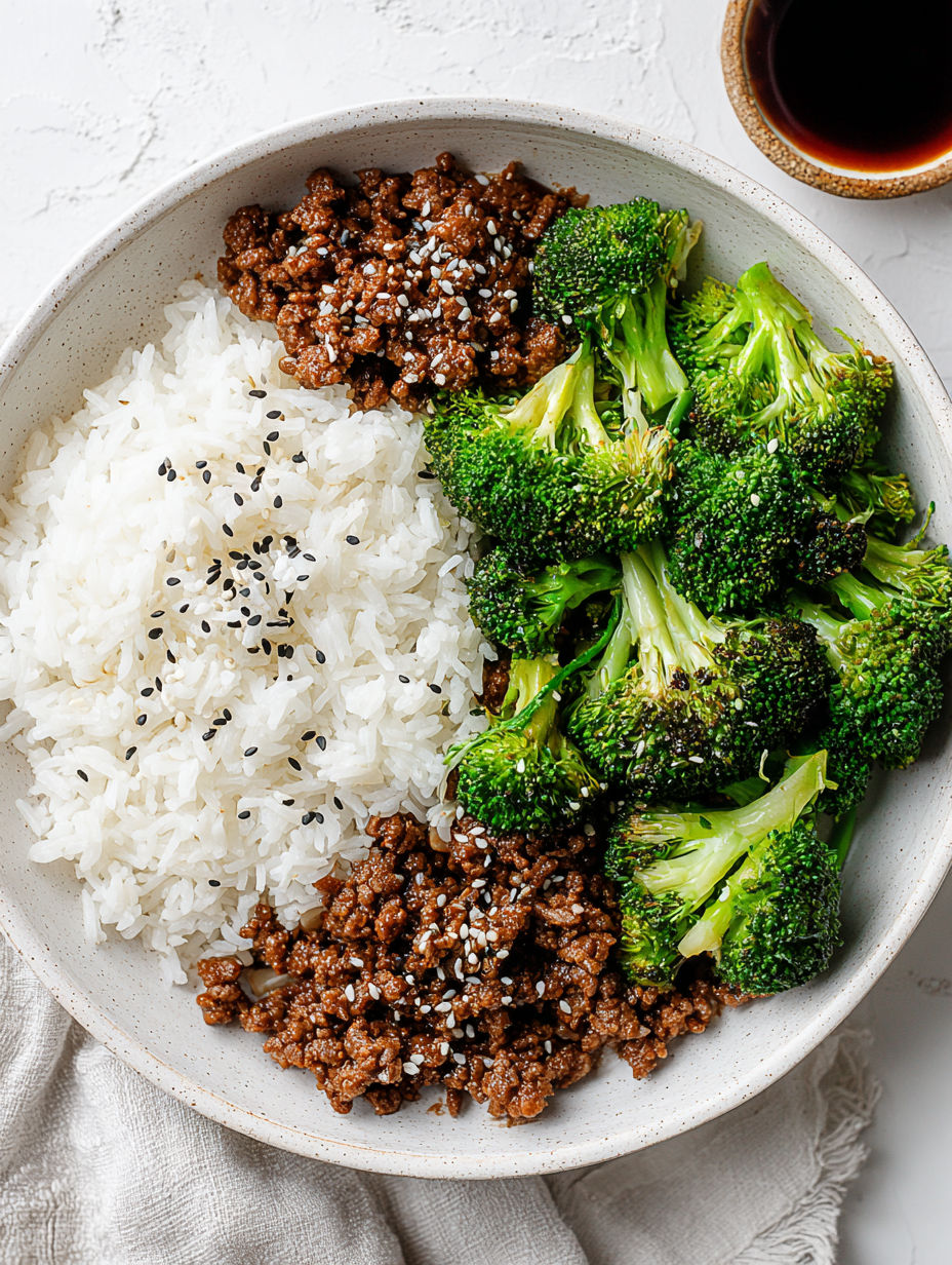 A bowl of ground beef and broccoli stir fry with rice.