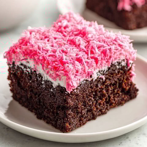 A slice of pink and brown cake with white frosting.