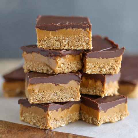 A stack of chocolate peanut butter bars with oats.