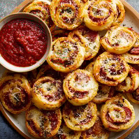 A plate of pizza wheels with sauce.