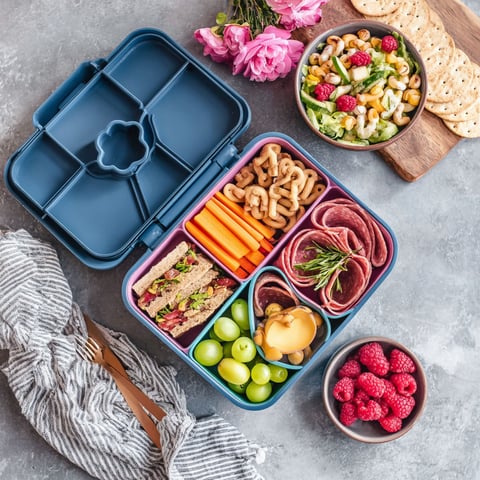 A blue lunch box with a variety of food items.