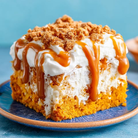 A slice of pumpkin spice poke cake on a blue plate.