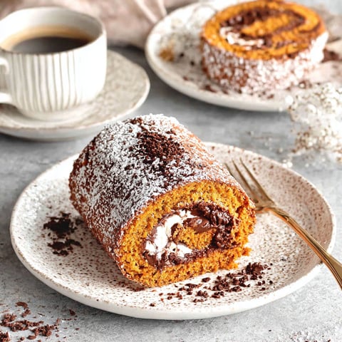 A small pumpkin roll cake with chocolate filling.