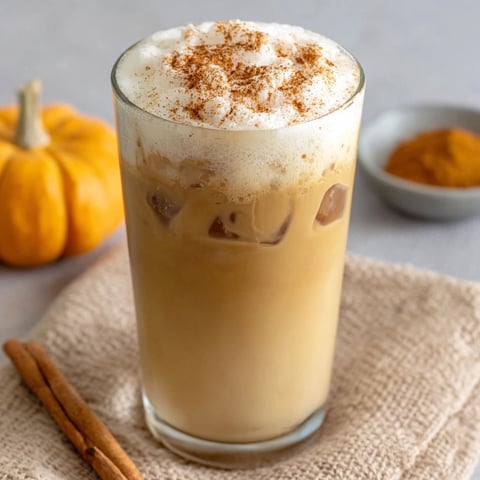 A glass of iced chai tea latte with pumpkin cold foam.