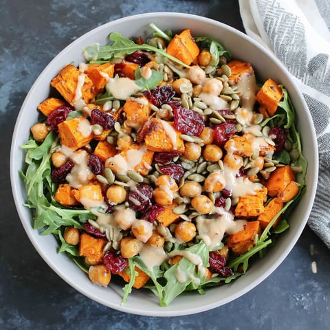 A bowl of roasted chickpea and sweet potato salad with sweet tahini dressing.