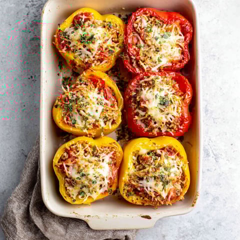 A dish of stuffed peppers with cheese and ground chicken.