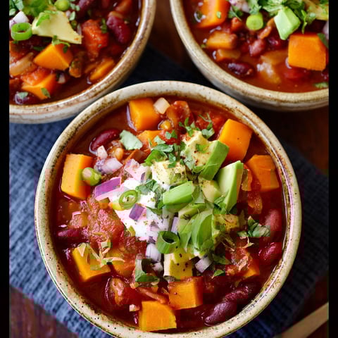 Three bowls of chili with butternut squash.
