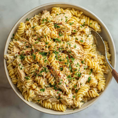 A bowl of pasta with chicken and garlic.