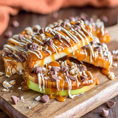 Caramel apple slices on a wooden board.