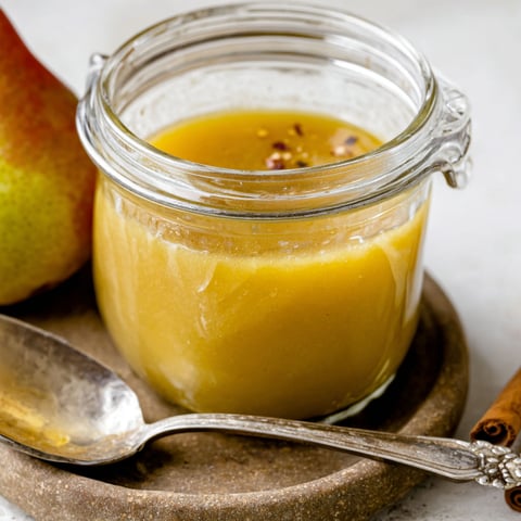 A glass of spiced pear and apple cider reduction dressing.
