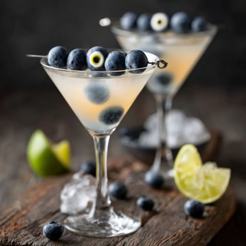 A glass of blueberries with a blueberry in the center.
