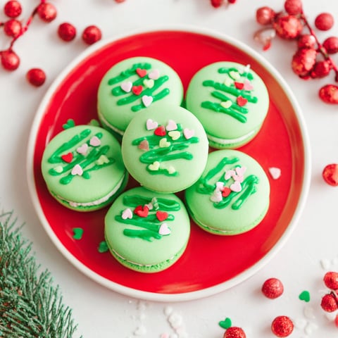 A plate of green and white cookies with hearts on them.