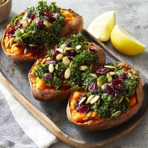 Two sweet potatoes with greens on top.
