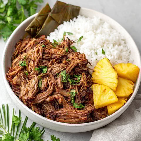 A bowl of slow cooker Kalua pork with rice and pineapple.