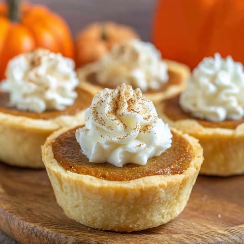Three mini pumpkin pies with whipped cream.