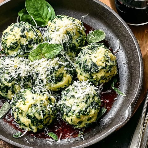 A plate of spinach ricotta dumplings with savory sage butter.